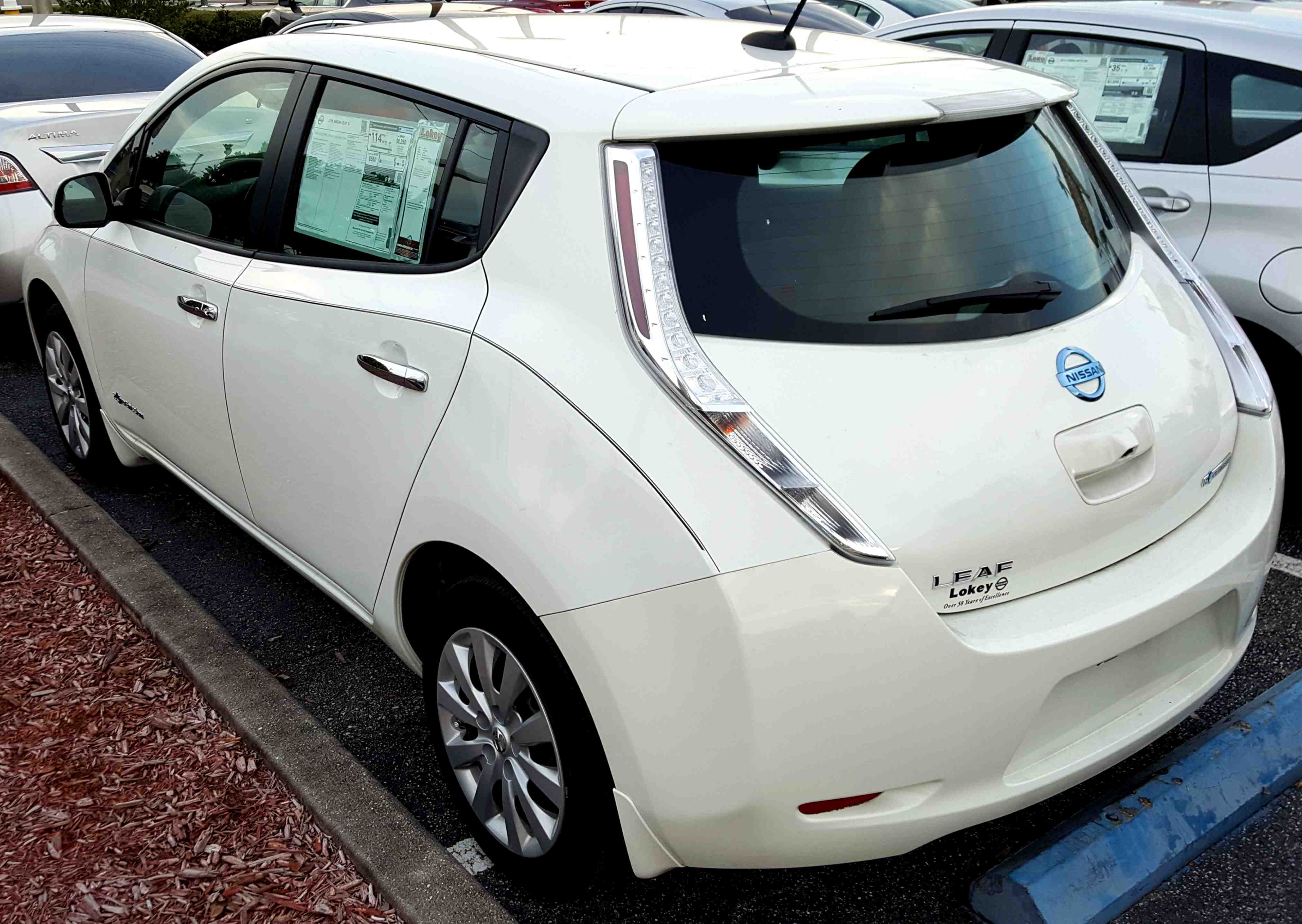 The rear view of a white 2015 Nissan Leaf
