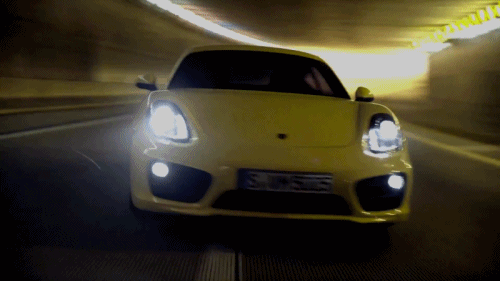 A yellow, 325 HP, 2012 Porsche Cayman S driving through a tunnel. (Animated GIF)